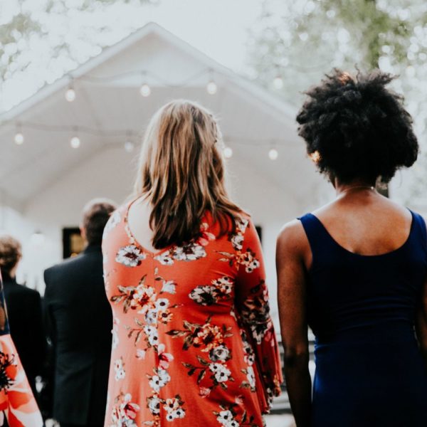 Guests at outdoor wedding facing white chapel