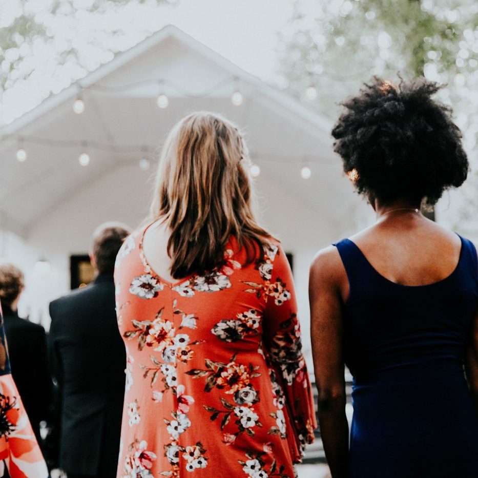 Guests at outdoor wedding facing white chapel