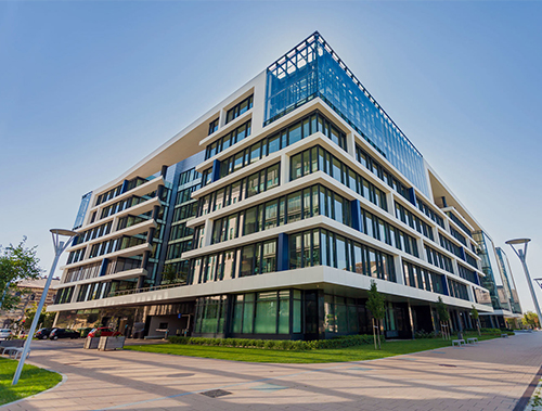Modern glass office building with landscaped plaza